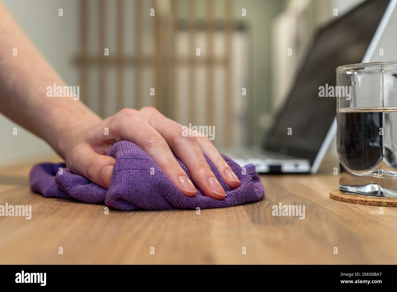Hand cleaning office, home desk, wood table surface from dust