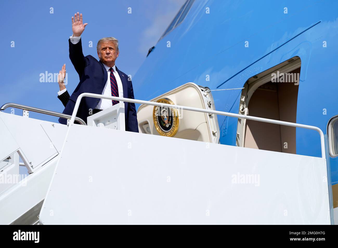 President Donald Trump waves as he and first lady Melania Trump board ...