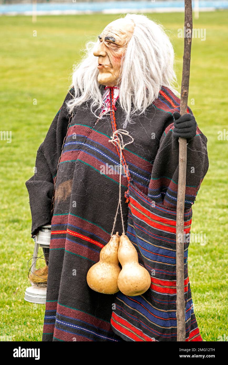 Participant in funny costume as old man at annual Simitlia winter Kukeri festival in Simitli, Blagoevgrad County, Bulgaria, Eastern Europe, Balkans Stock Photo