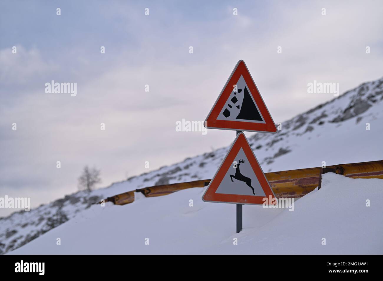 A driver with a snow plow vehicle breaks through the snow-covered road ...