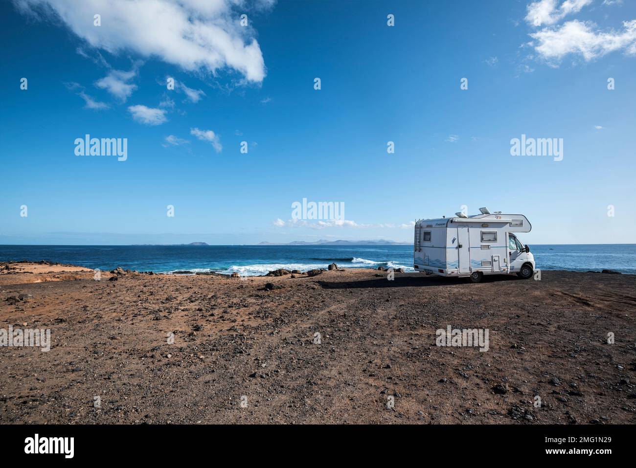 Campervan, motorhome parked at remote location on beach overlooking Ocean. Stock Photo
