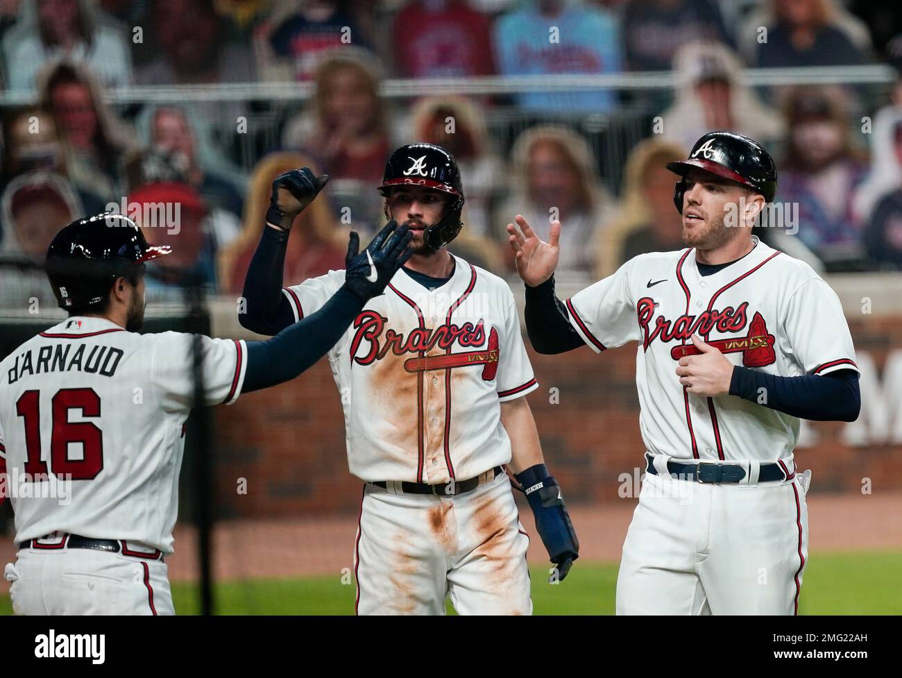 Atlanta Braves' Dansby Swanson, center, and Rafael Ortega, right