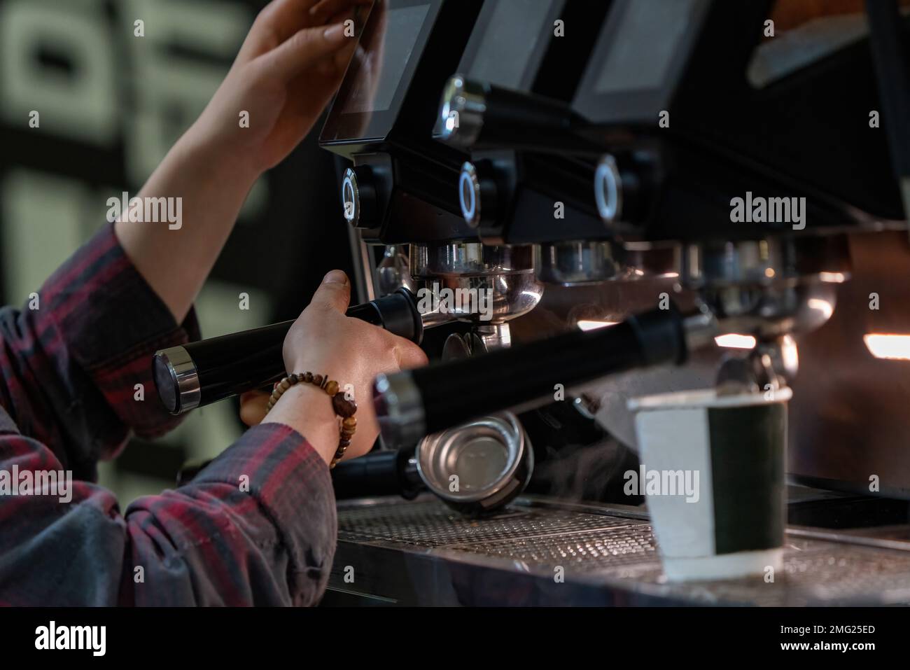 Barista frothing milk to make coffee. Barista hands in front of coffee