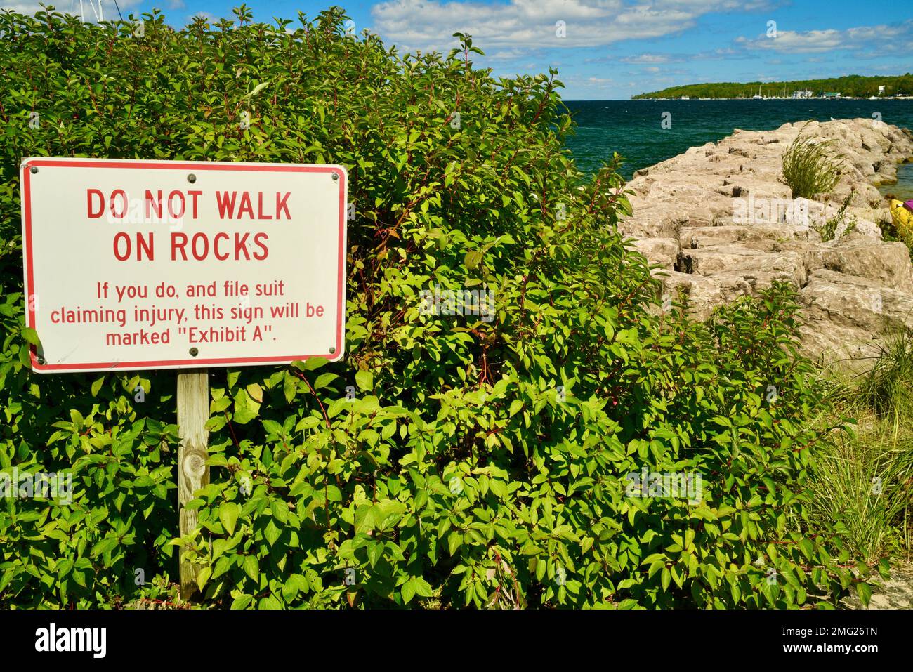 Funny warning 'Do Not Walk On Rocks' sign posted at edge of harbor in Door County, Sister Bay, Wisconsin, USA Stock Photo