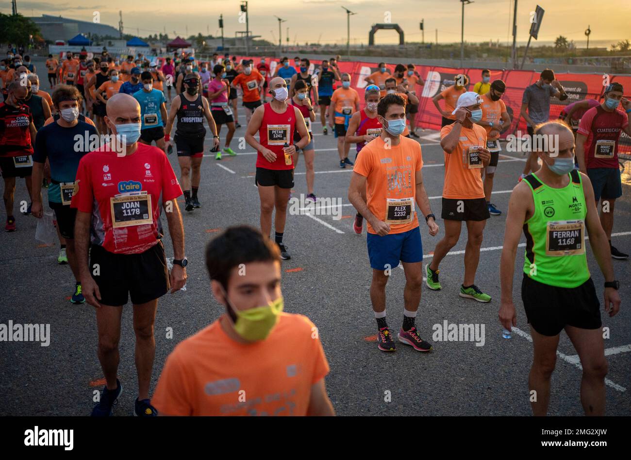Athletes wearing face masks to prevent the spread of coronavirus keep their  positions before taking part in "La Cursa de la Mercè" race, one of the  most emblematic events of Barcelona's sporting