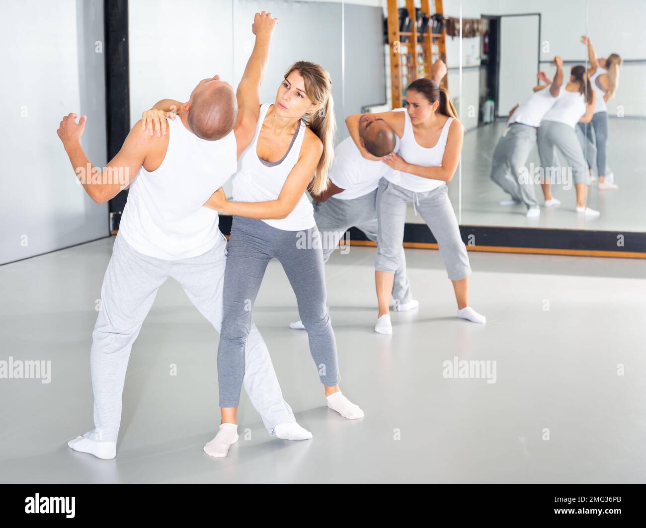 Woman and her trainer are practicing karate on the self-defense course Stock Photo