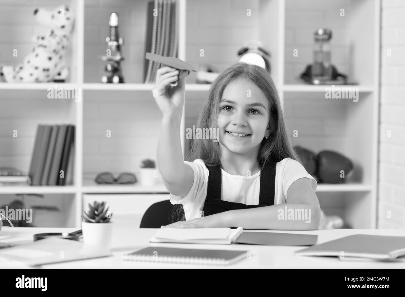 smiling child play with paper plane in school classroom Stock Photo