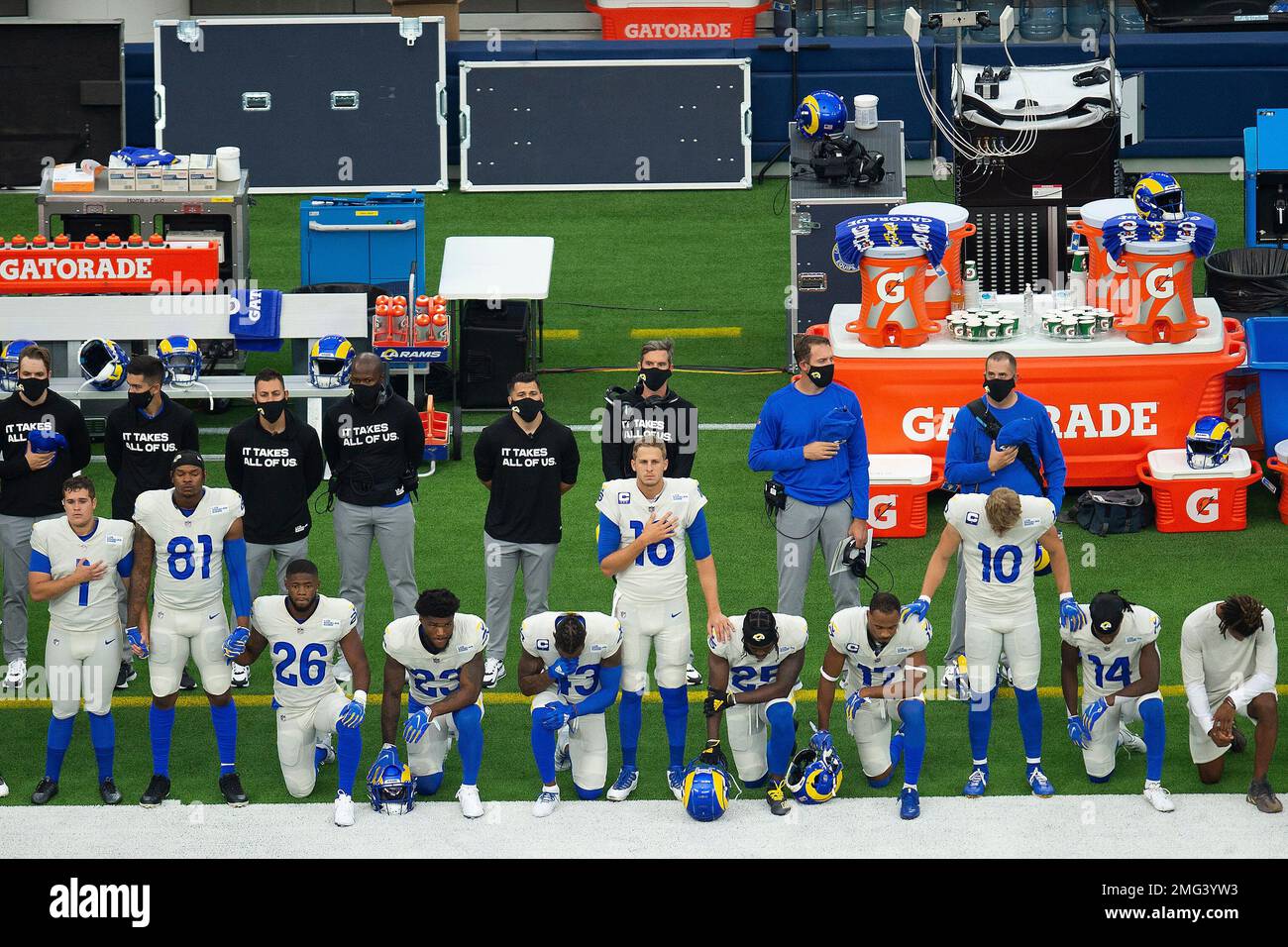 Members of Los Angeles Rams players stand and kneel during the National