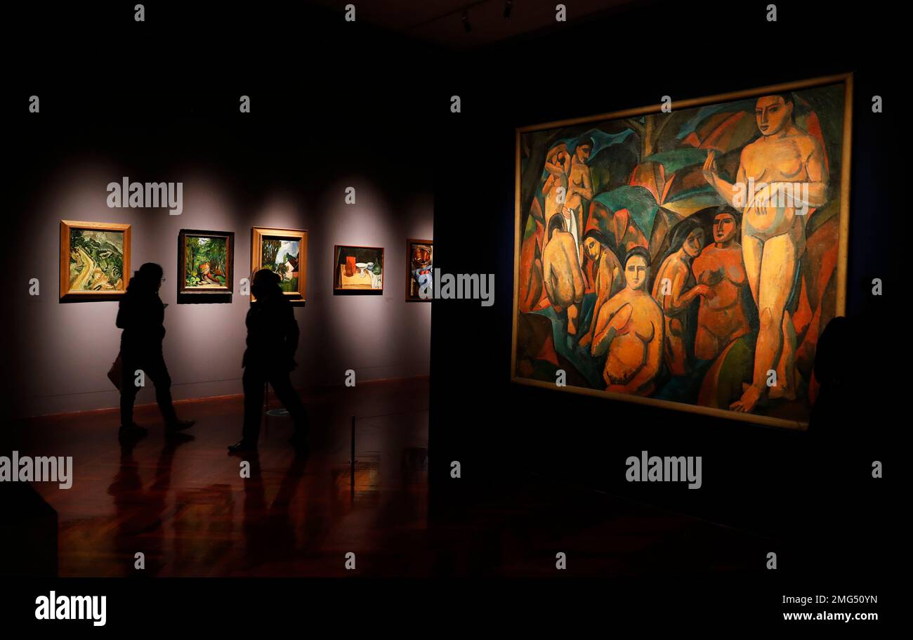 Journalists walk past a painting by Andre Derain, left, during the 