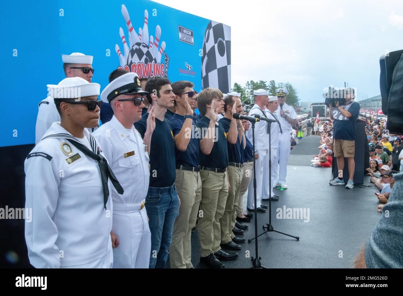 220821-N-IUK583-0054 WATKINS GLEN, N.Y. (August 21, 2022) — Cmdr. Christopher McCurry, commanding officer of Navy Talent Acquisition Group (NTAG) Pittsburgh, administers the oath of enlistment for eleven future Sailors at the Go Bowling at The Glen, NASCAR Xfinity Series race. NTAG Pittsburgh, part of Navy Recruiting Command, recruits the next generation of Navy Sailors throughout areas in Pennsylvania, New York, West Virginia, and Maryland. Stock Photo
