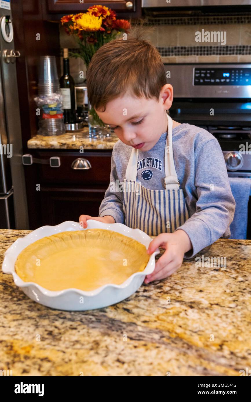 Three year old boy helping grandmother bake a Thanksgiving holiday apple pie; Philadelphia; Pennsylvania; USA Stock Photo