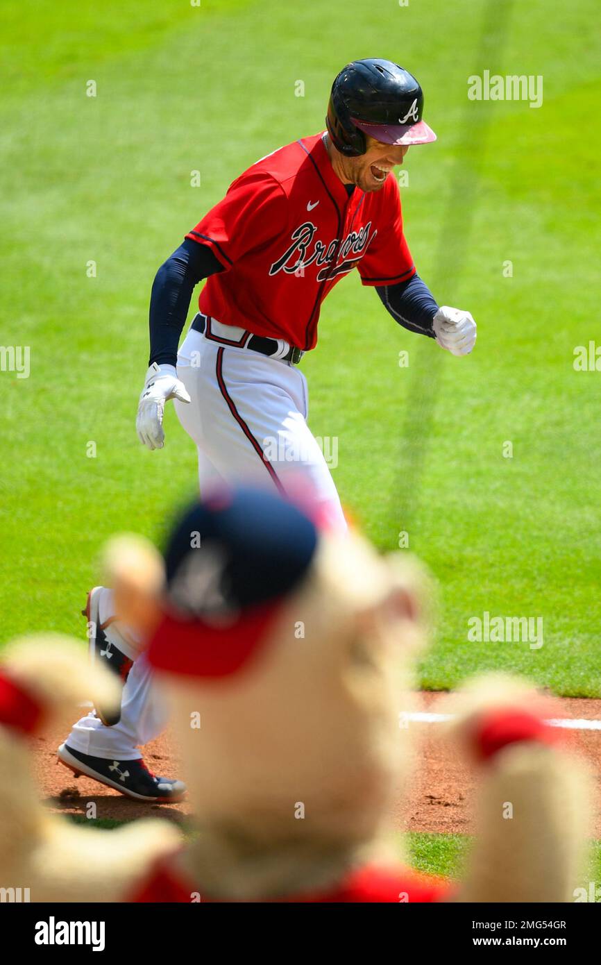 Atlanta Braves' Freddie Freeman reacts as he runs the third base line with  mascot Blooper cheering during his grand slam home run in the sixth inning  of a baseball game against the