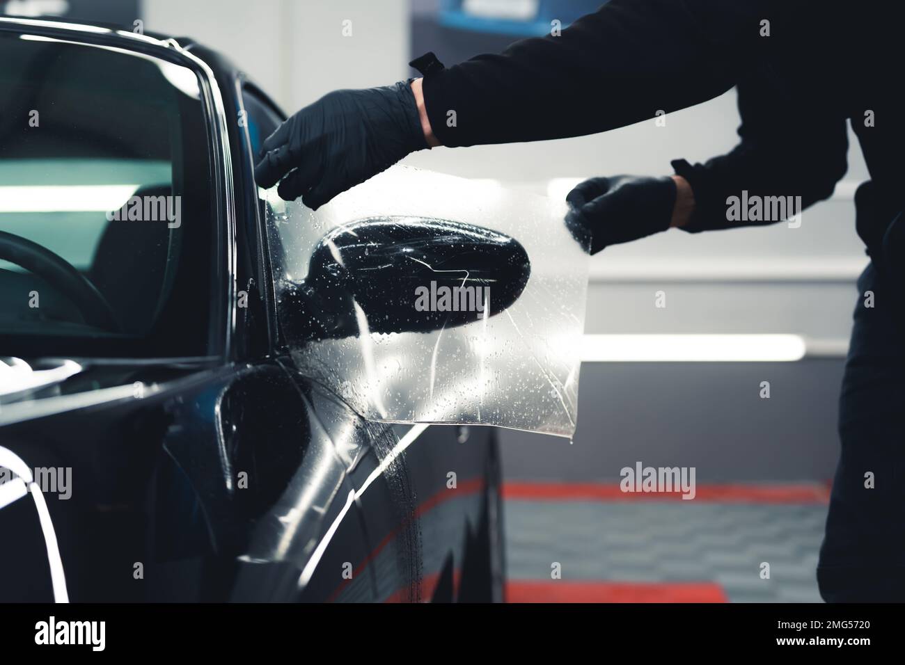 Unrecognisable man wearing black gloves leaning over stretching PPF
