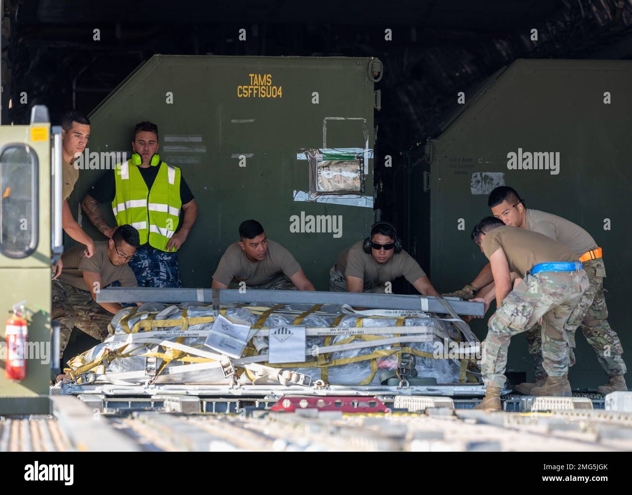 U.S. Air Force and Royal Australian Air Force Airmen unload a pallet from a C-17 Globemaster III at RAAF Base Tindal, Northern Territory, Australia, Aug. 22, 2022. Airmen train alongside Allies and partners to enhance interoperability and bolster the collective ability to support a free and open Indo-Pacific. Stock Photo