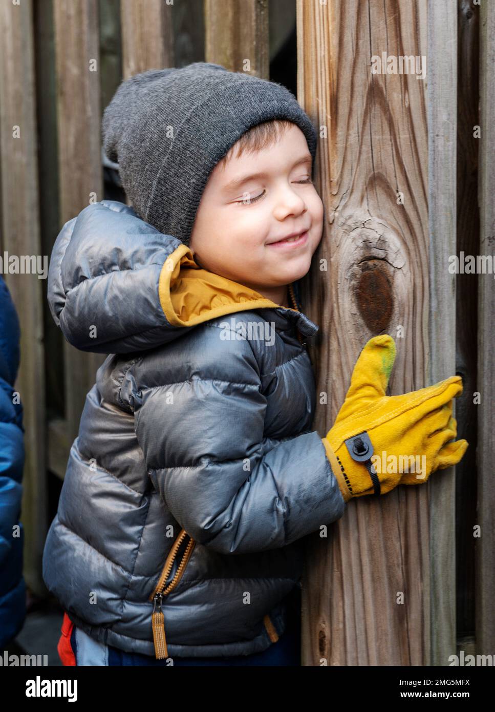 Smiling three year old boy bundled for winter playing in residential backyard; Philadelphia; Pennsylvania; USA Stock Photo