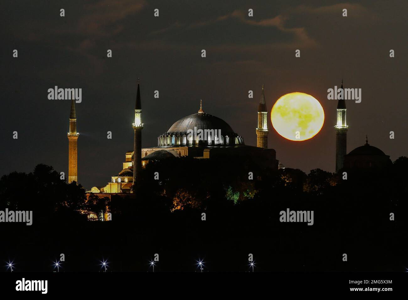 The full moon rises behind the Byzantine-era Hagia Sophia, in the ...