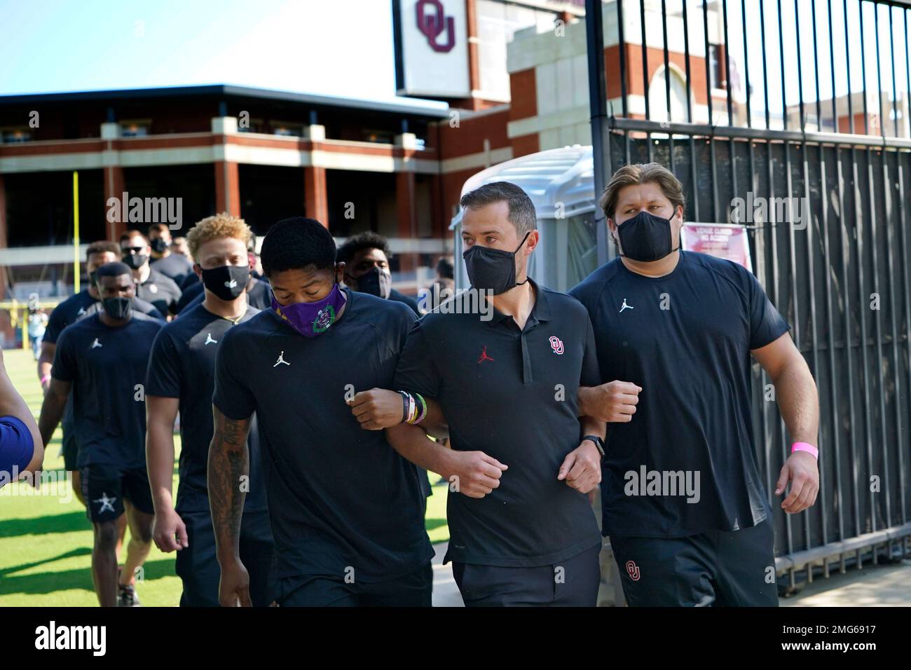 Defensive back Chanse Sylvie, left, head coach Lincoln Riley, center ...