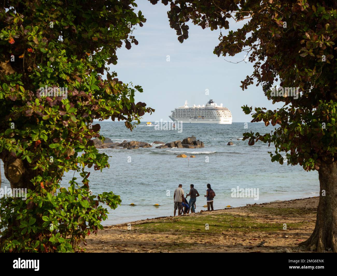 beautiful framing of passenger ship and family playing at beach Stock