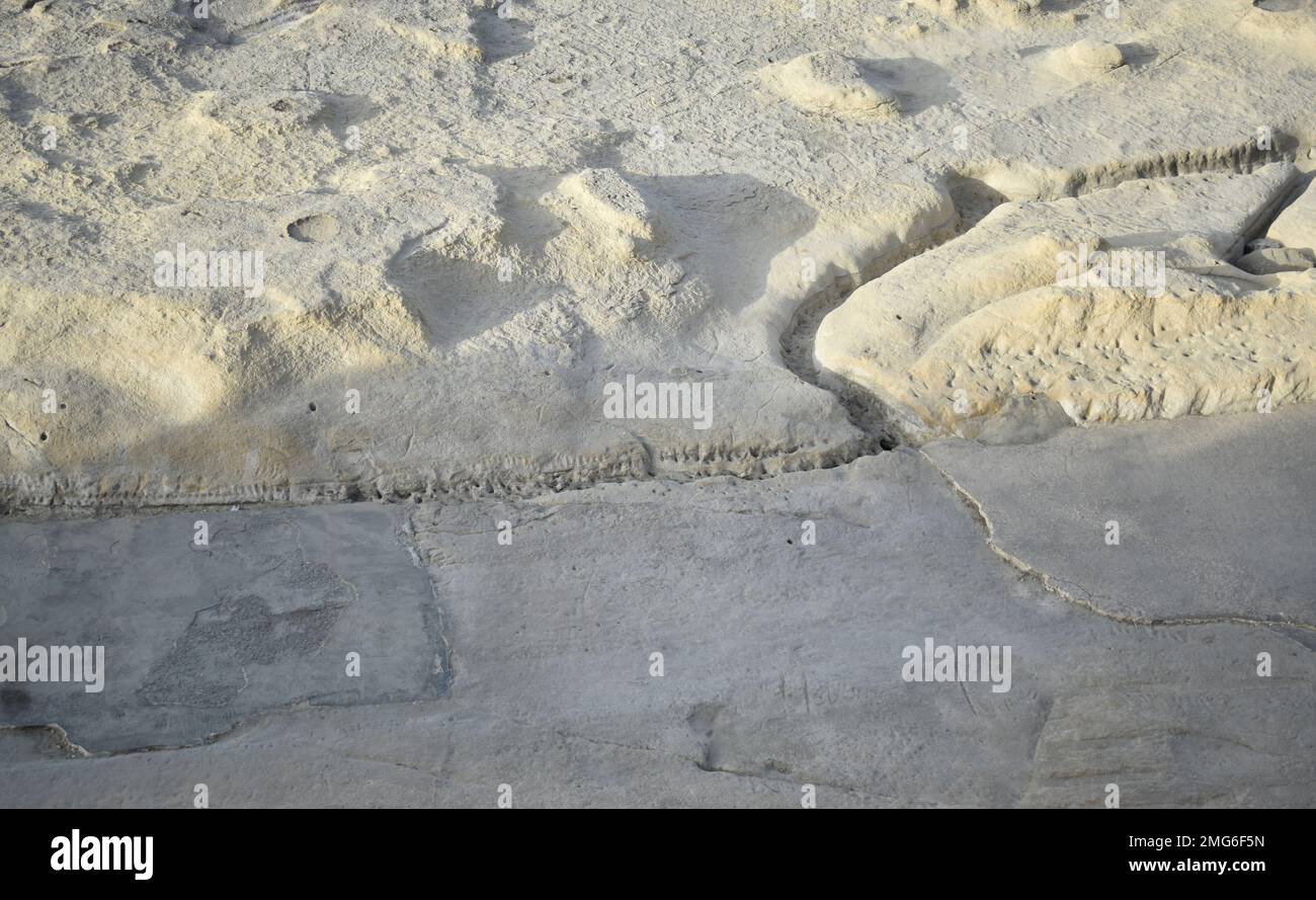 Part of a sunny beach in Malta with an unusual rocky relief. Background. Stock Photo