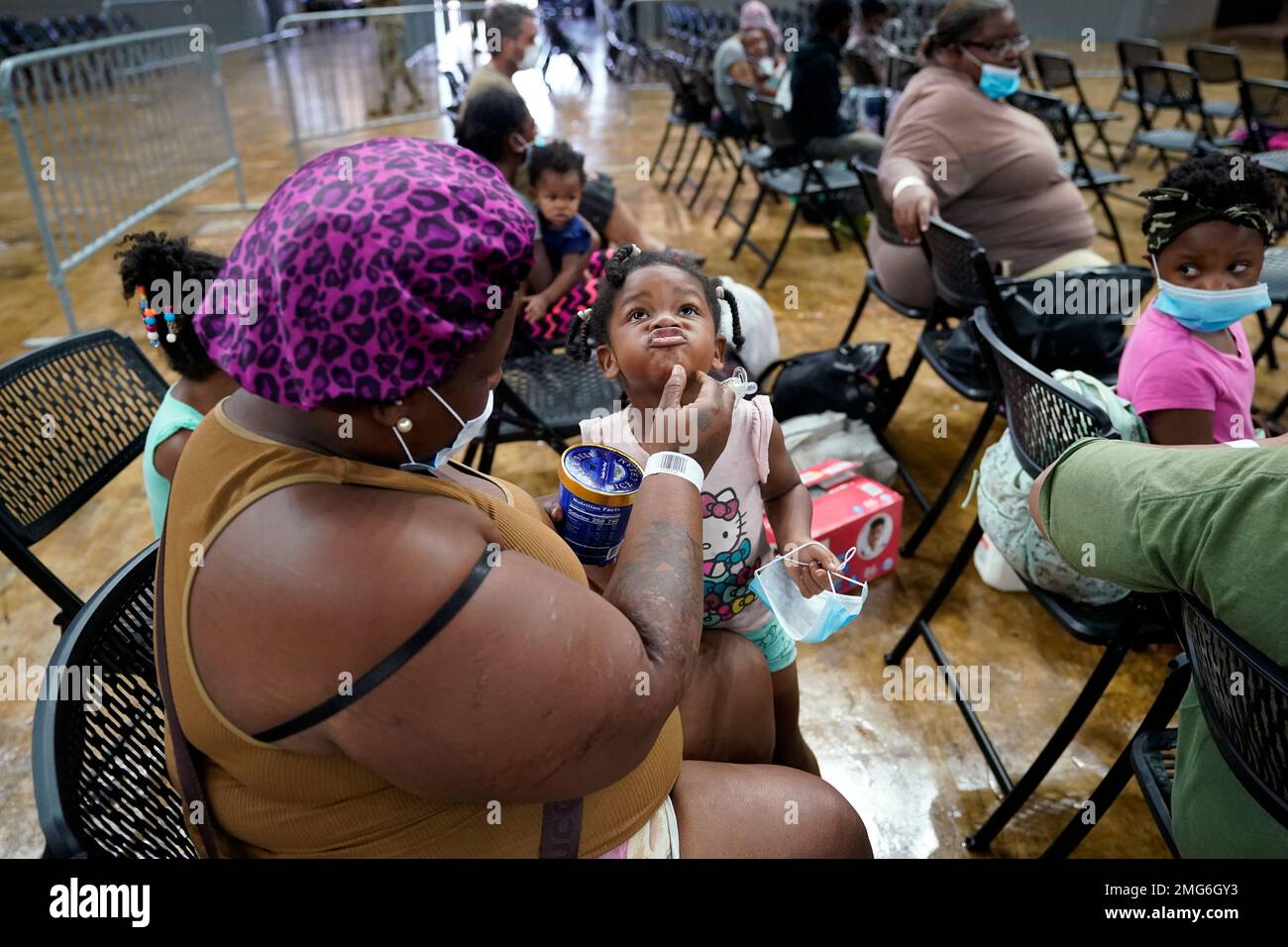Jada Lawson, wipes the face fo her daughter Skyler Lawson, 4, as they wait to board
