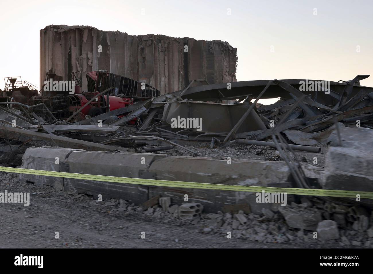 A damaged grain silo is surrounded by rubble and debris at the site of