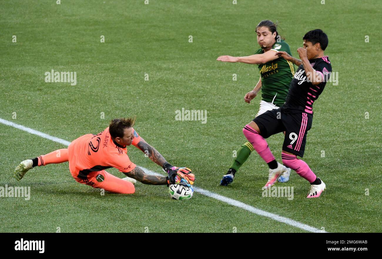Portland Timbers goalkeeper Steve Clark, left, blocks the shot of