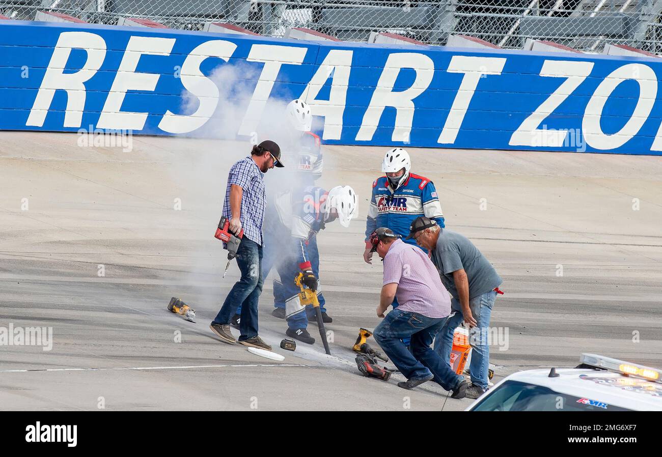 Track crews repair damage to the concrete in Turn 4 during a NASCAR Cup