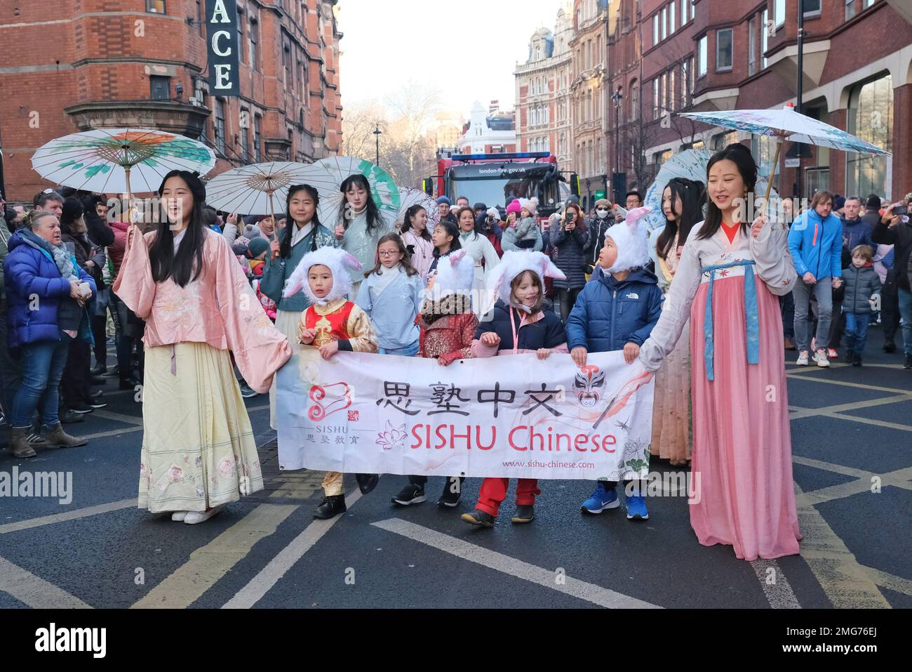 London, UK. Chinese New Year parade participants greet the crowds as ...