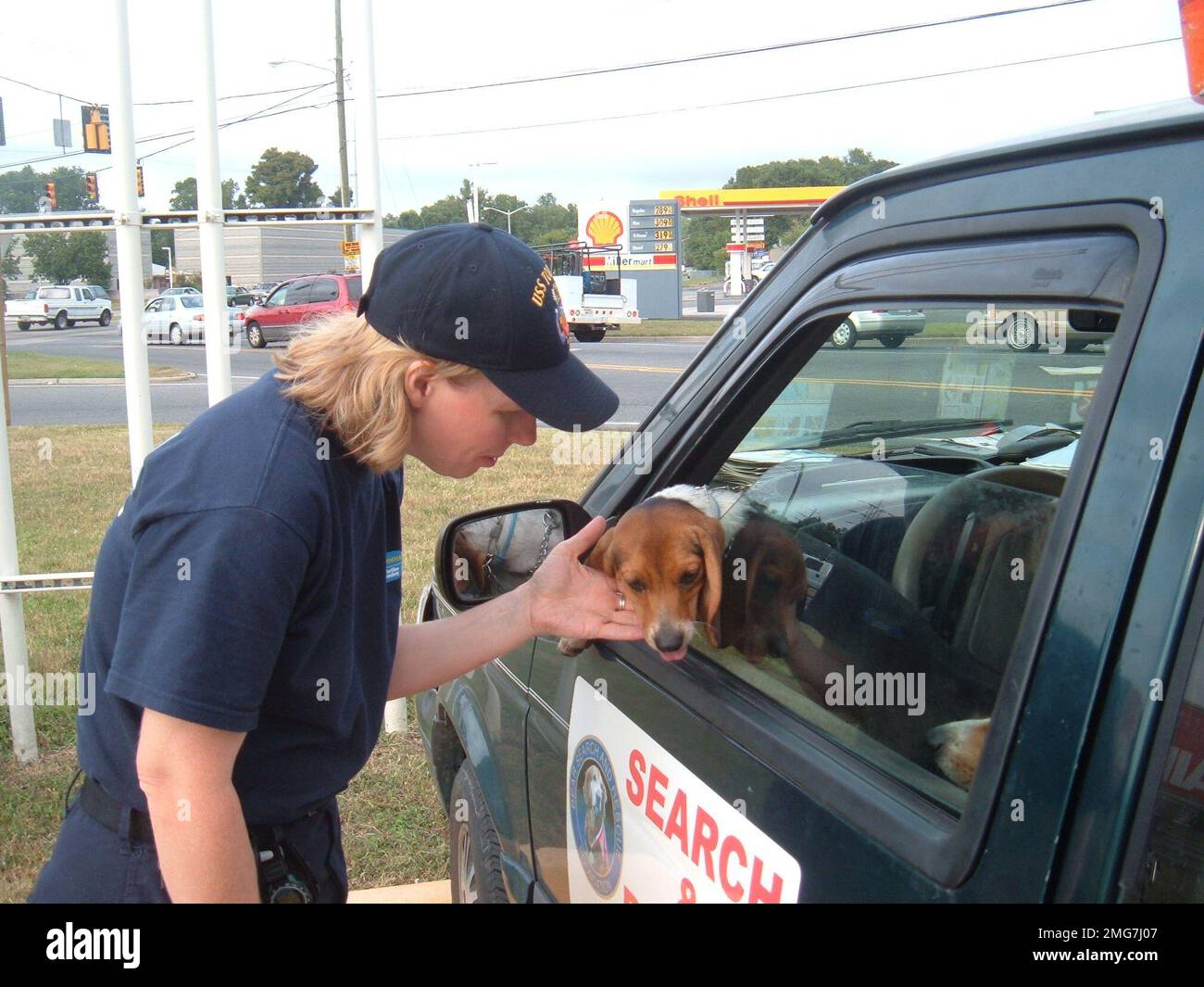 Animals - 26-HK-59-5. dog leaning out window of search-and-rescue vehicle, being petted by personnel near commercial street -- 050916. Hurricane Katrina Stock Photo