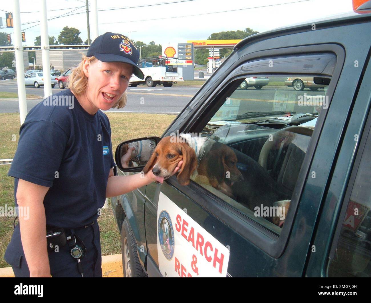 Animals - 26-HK-59-6. dog leaning out window of search-and-rescue vehicle, being petted by personnel near commercial street --050916. Hurricane Katrina Stock Photo