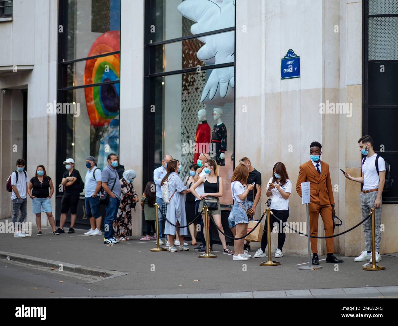 Paris. 11th May, 2020. Customers wearing protective face masks queue outside  the Louis Vuitton store before its reopening on the Champs Elysee avenue in  Paris, France on May 11, 2020. France started