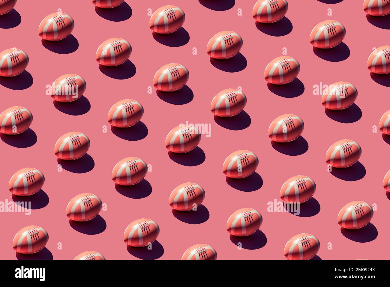 Pattern of pink American football rugby balls with hard shadow on pink ...