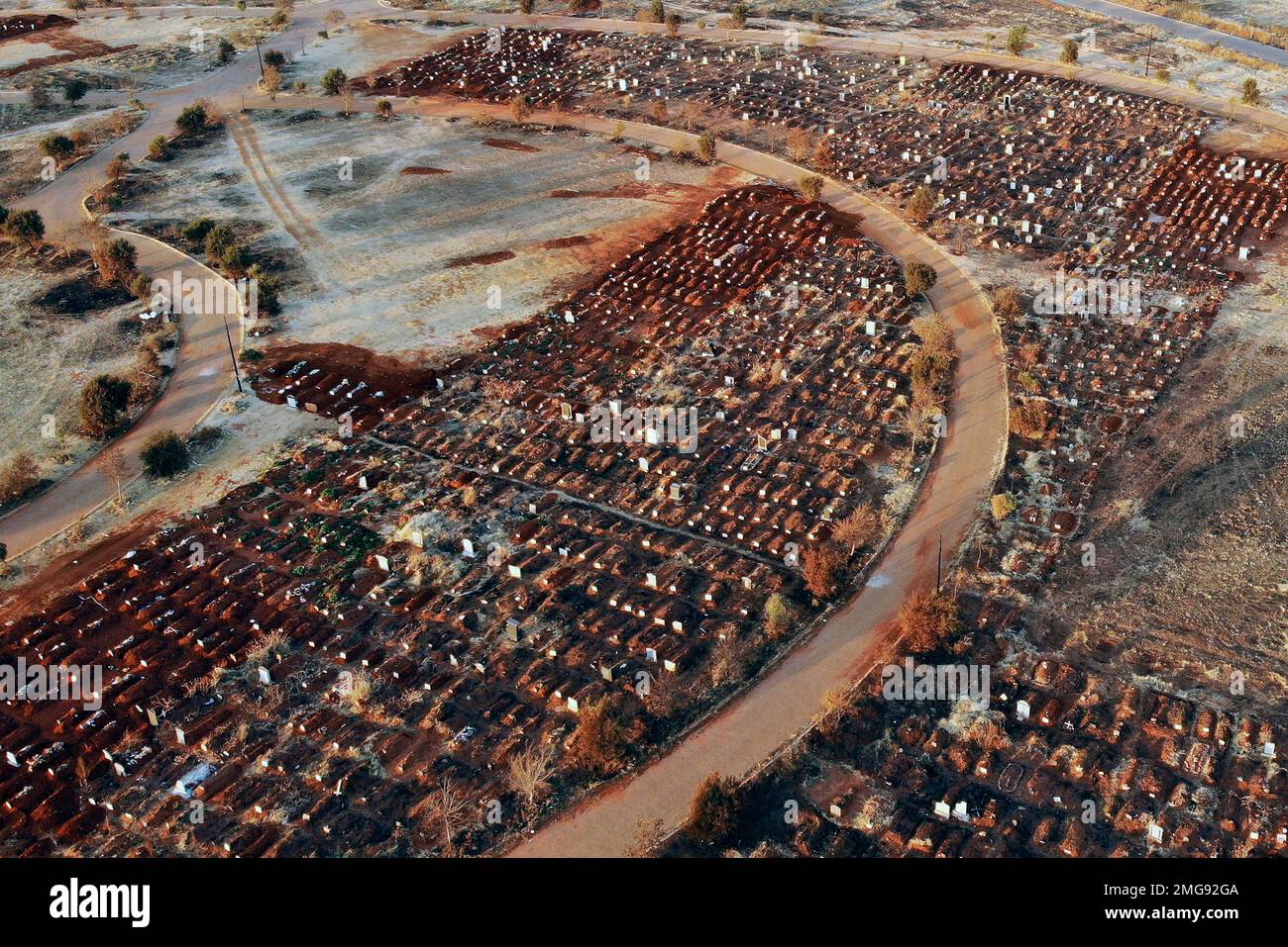 Recently filled graves are seen in the Olifantsveil Cemetery outside ...