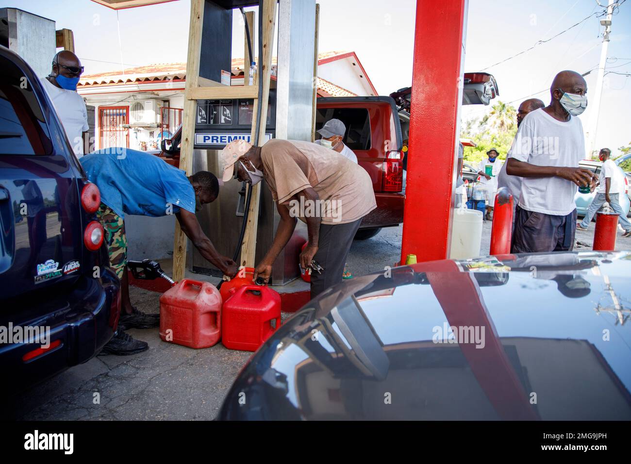 Residents fill their containers with gasoline at Cooper's gas station