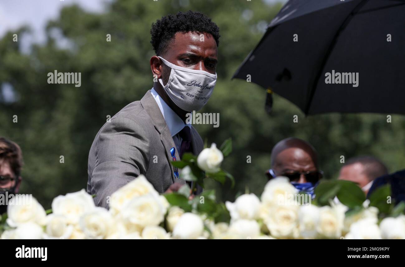 Roses are placed on the casket at the burial service for Rep. John