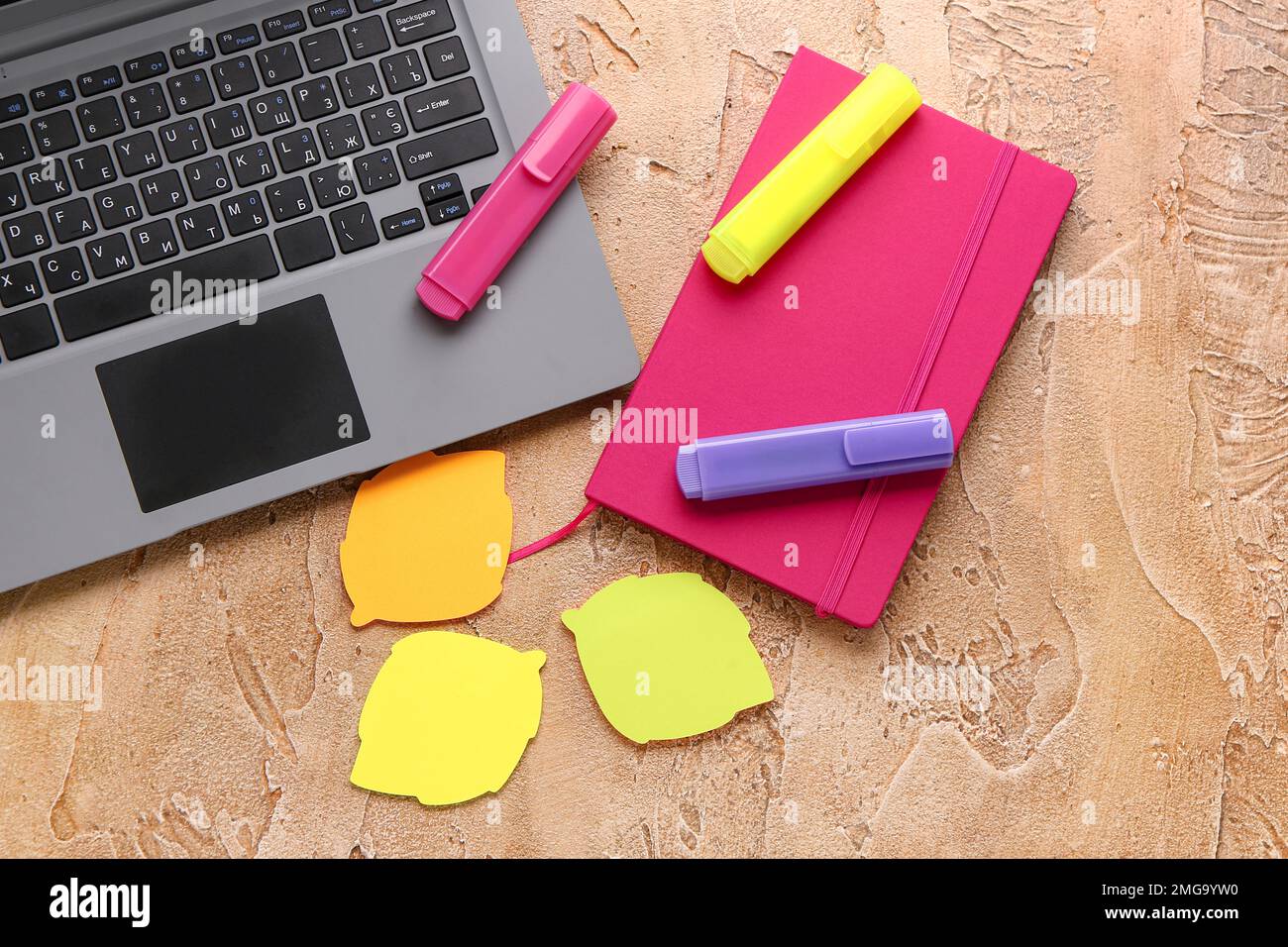 Notebook, laptop, sticky notes and markers on color background Stock