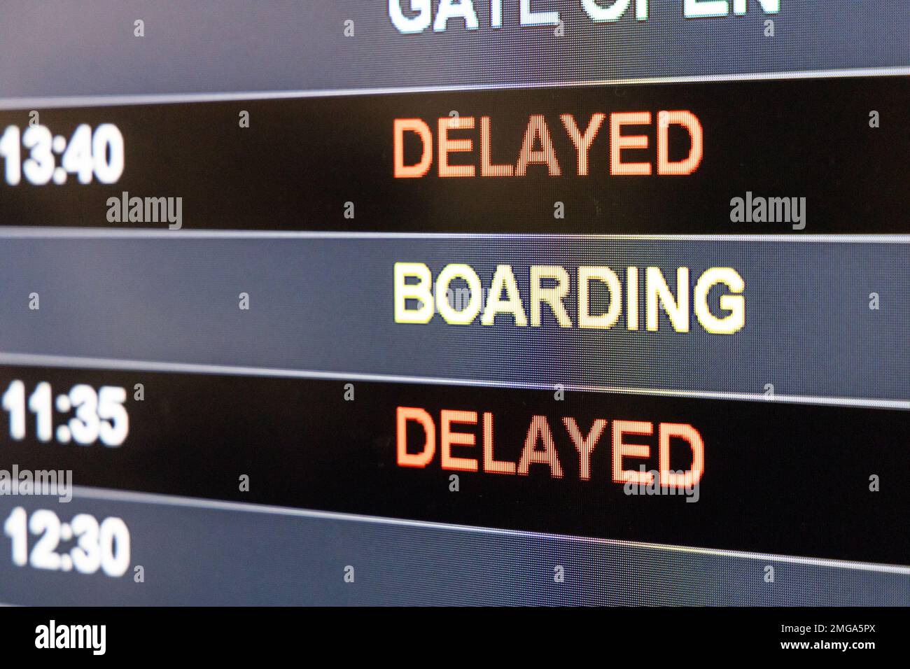 Close-up on airport flight information digital board with focus on the word Delayed Stock Photo