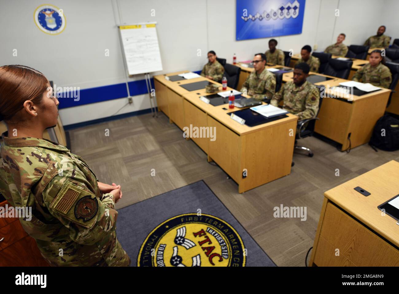 U.S. Air Force Staff Sgt. Jeydi Delgado, 325th Force Support Squadron First Term Airman Course noncommissioned officer in charge of FTAC, left, gives a briefing at Tyndall Air Force Base, Florida, Aug. 22, 2022. Tyndall’s FTAC has a dedicated staff intent on offering the best curriculum as possible to help pave to way for success as new Airmen transition into an operational role. Stock Photo