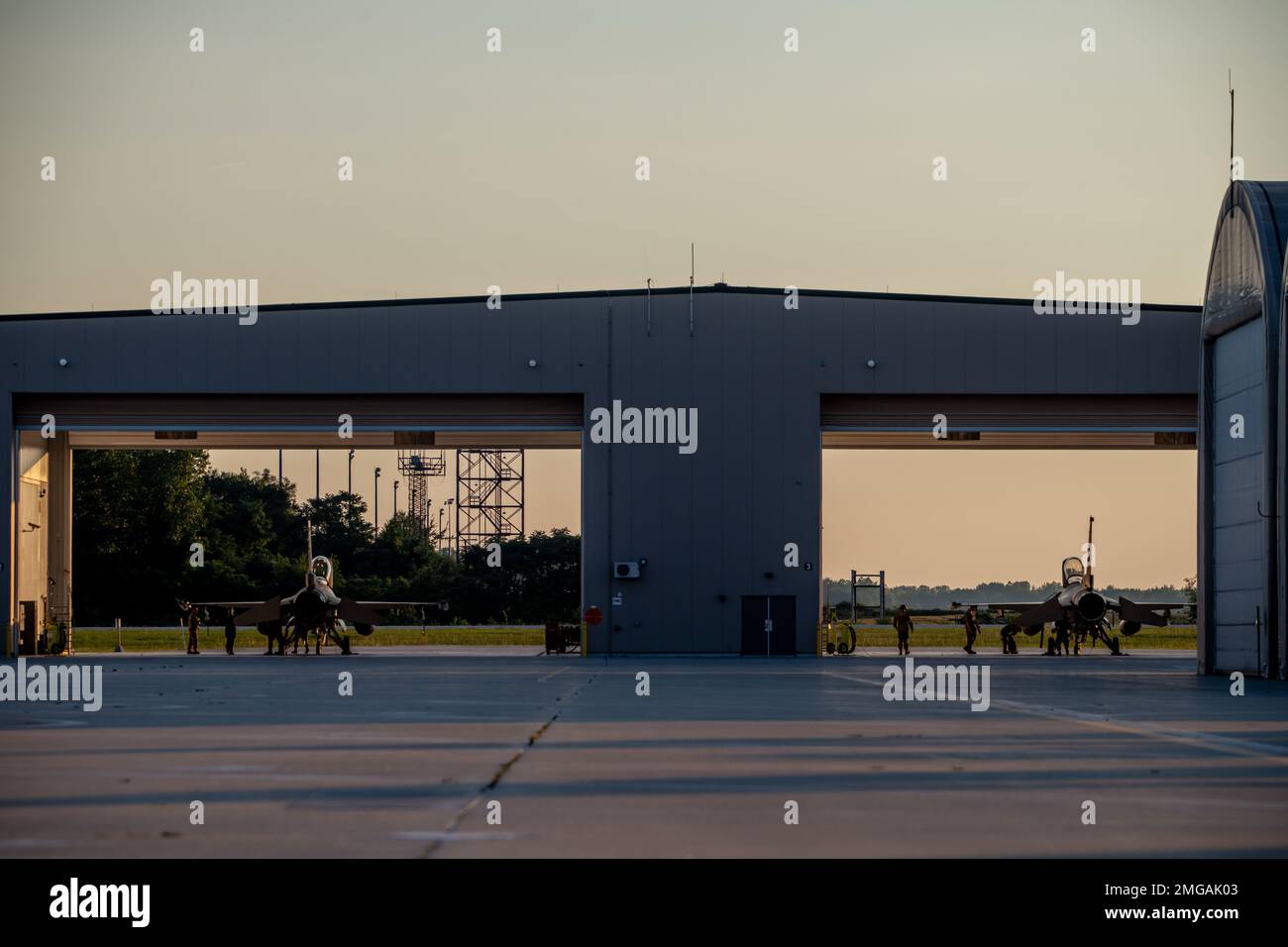 U.S. Air Force F-16 Fighting Falcons, assigned to the Ohio National Guard’s 180th Fighter Wing, sit in a hangar before a nighttime training flight at the 180FW in Swanton, Ohio, Aug. 22, 2022. The 180FW conducts training, rain or snow, day and night, to enhance mission readiness, ensuring effective combat power can be delivered to combatant commanders, anytime, anywhere. Stock Photo