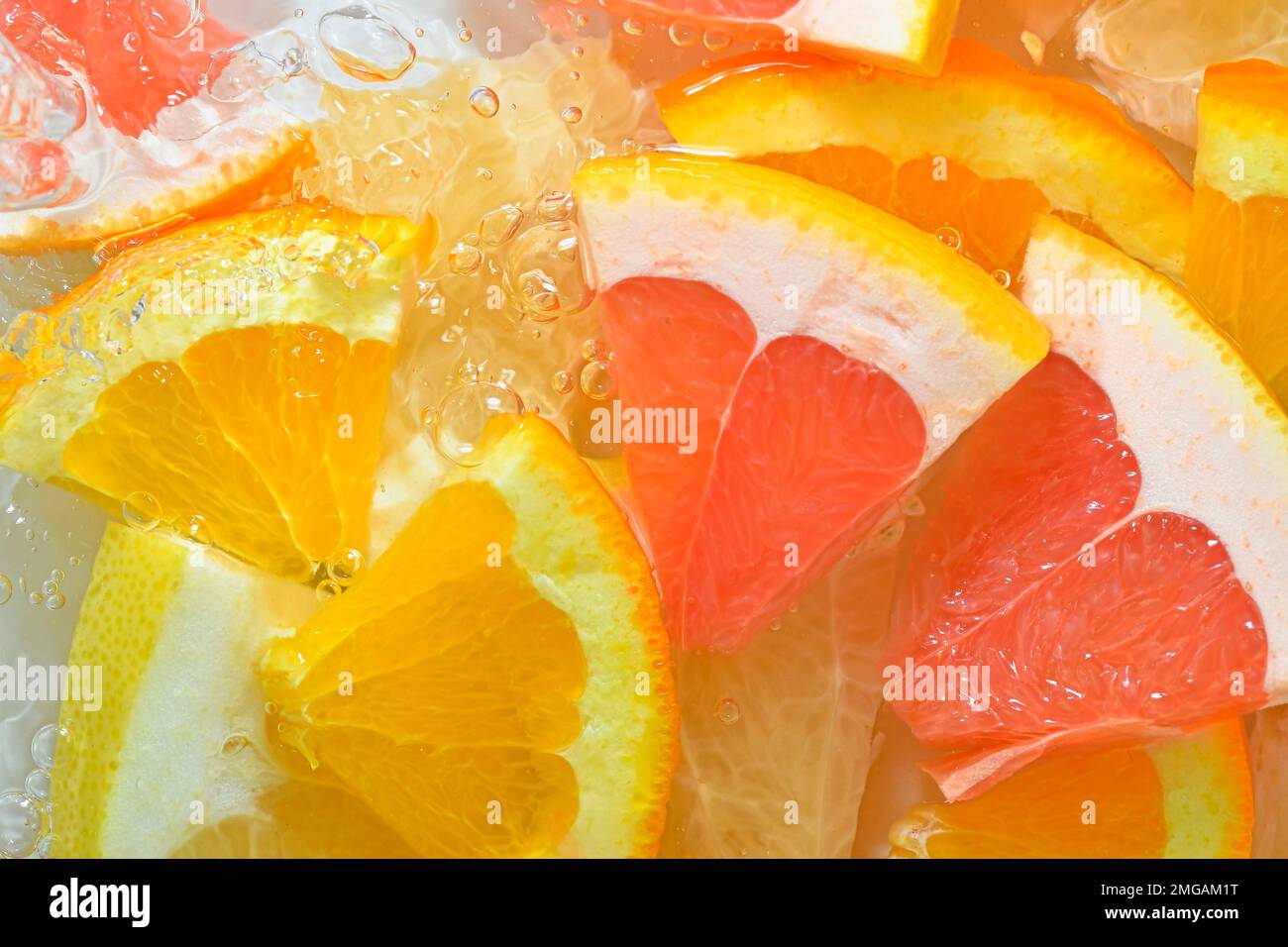 Fresh slices of grapefruit, orange fruit and honey pomelo on white background. Pieces of grapefruit, orange fruit and honey pomelo in sparkling water Stock Photo