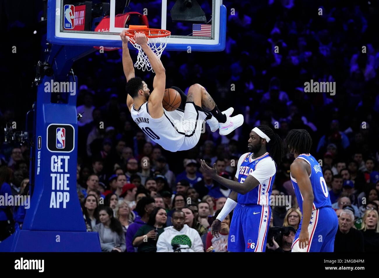 Brooklyn Nets' Ben Simmons, left, dunks as Philadelphia 76ers