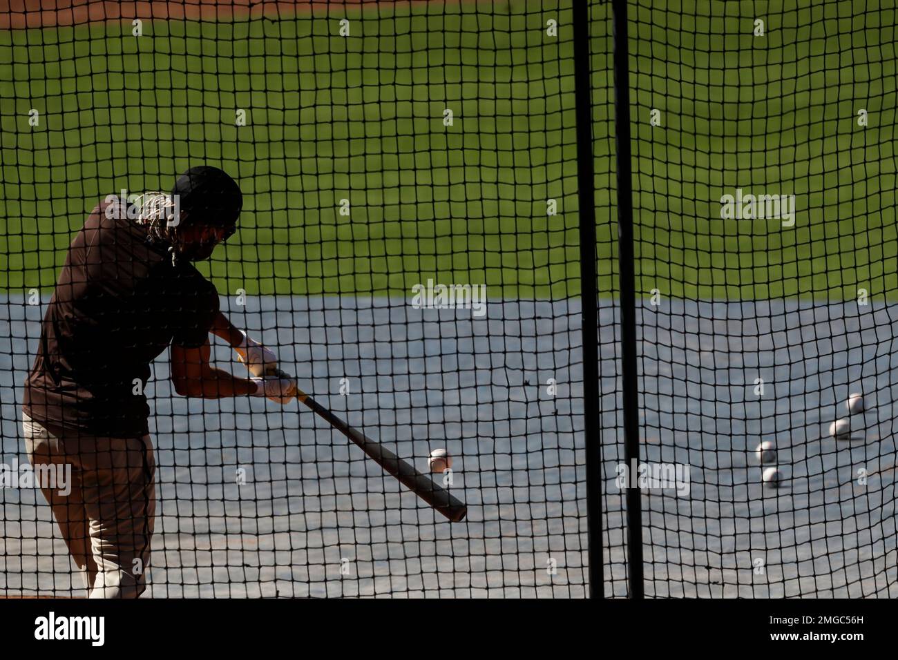 San Diego Padres' Fernando Tatis Jr. wears a mask as takes batting practice during a baseball