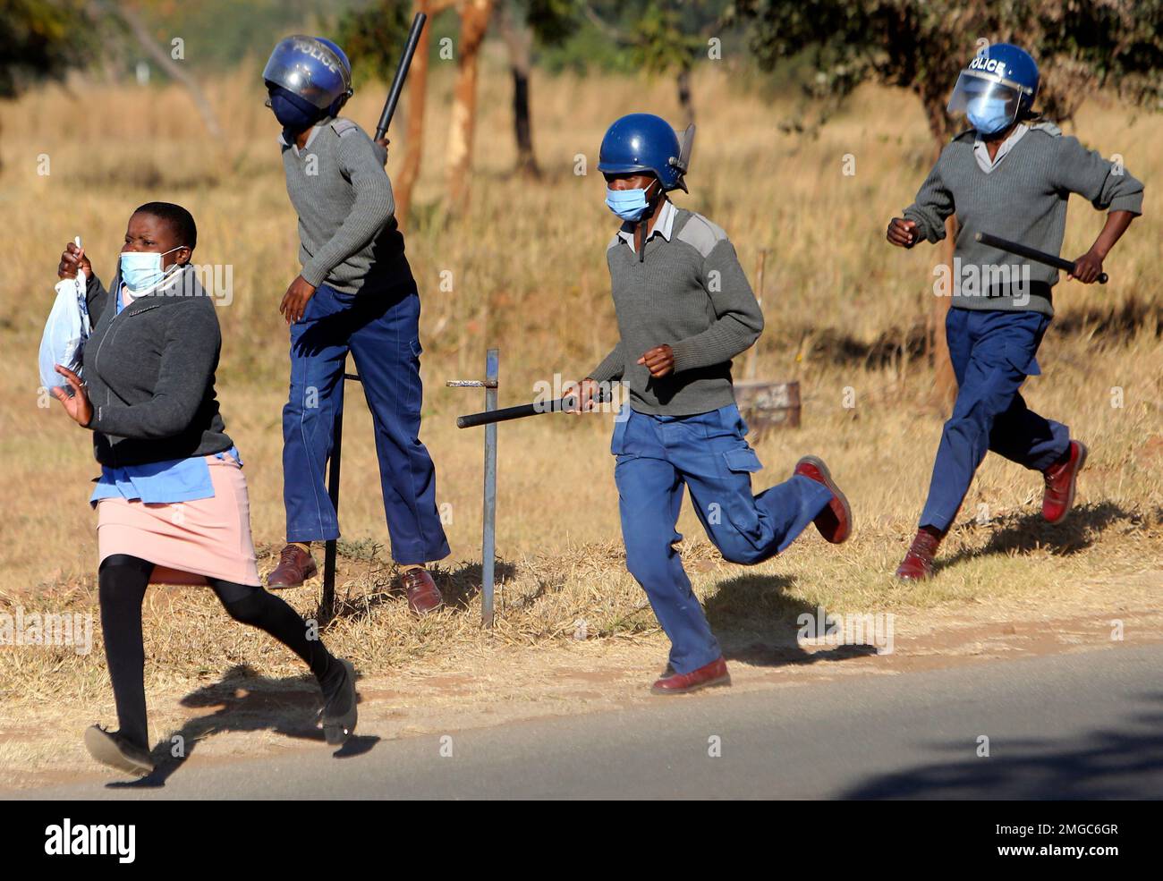 Riot police give chase a nurse who was protesting at a government ...
