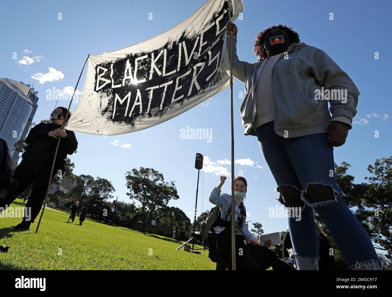A couple hold a banner as thousands gather at a rally supporting the ...