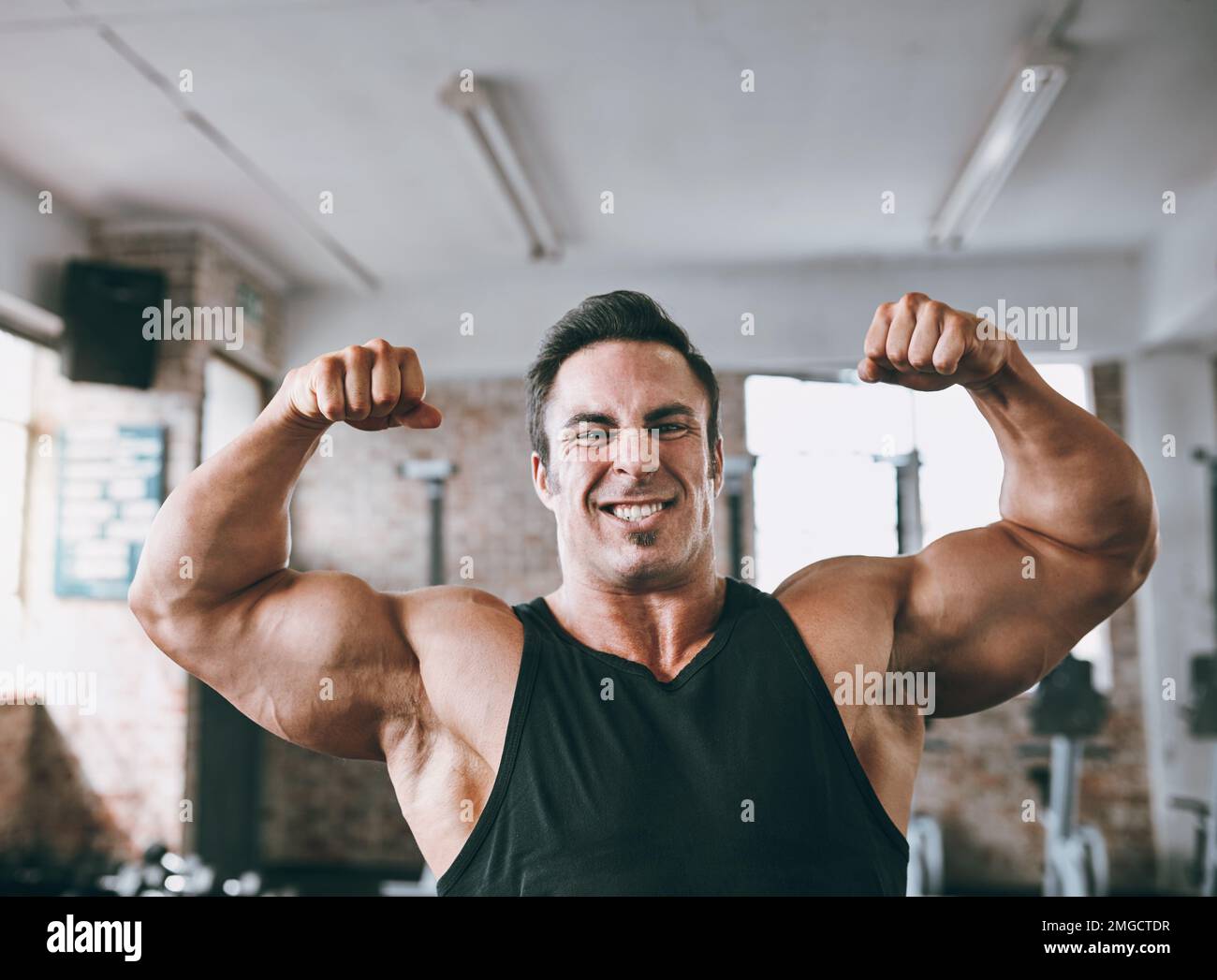 You can be anything you put your mind to. a young man flexing his muscles Stock Photo Alamy
