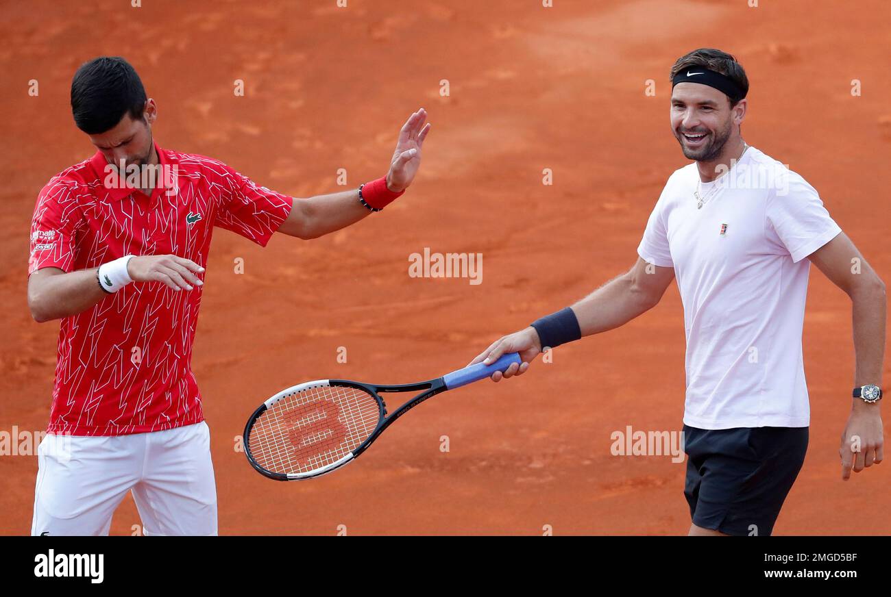 In this Friday, June 12, 2020 photo Bulgarias Grigor Dimitrov, right, speaks with Serbias Novak Djokovic during a rolling tennis doubles match of the Adria Tour charity tournament, in Belgrade, Serbia