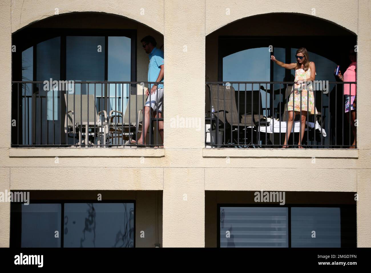 A few fans watch from a balcony overlooking the 18th hole during the final round of the RBC Heritage golf tournament, Sunday, June 21, 2020, in Hilton Head Island, S.C