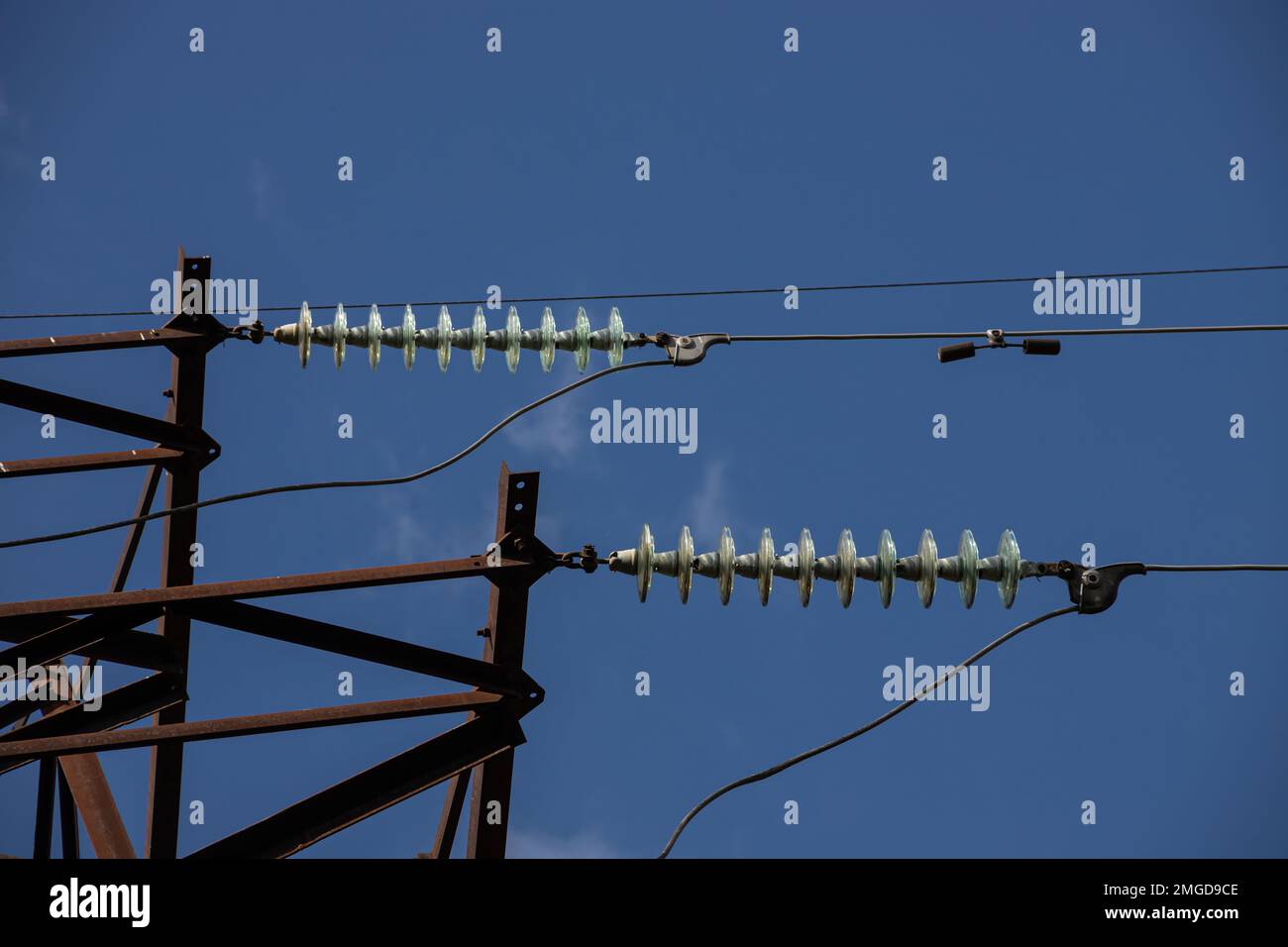 Power lines on background of blue sky close-up. Electric hub on pole. Electricity equipment with copy space. Wires of high voltage in sky. Stock Photo