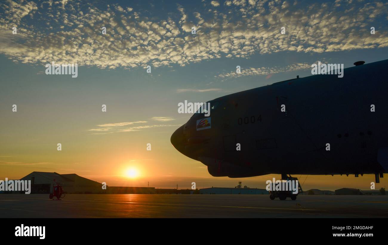 The sun rises over a B-52H Stratofortress parked on the flight line at ...