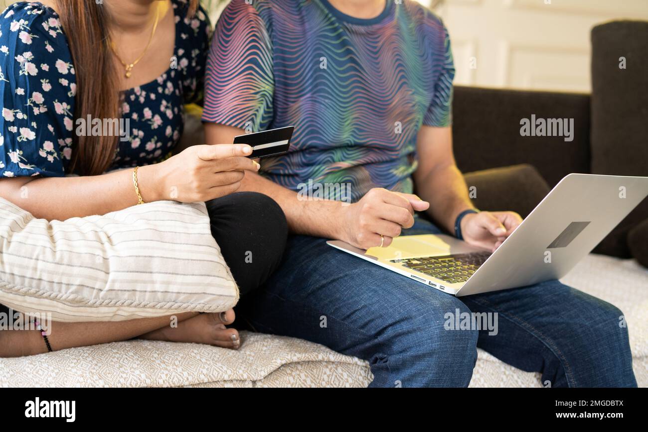 Close up shot of couple making online payment for shopping using credit card on laptop at home - concept of secure transaction, ecommerce and finance Stock Photo